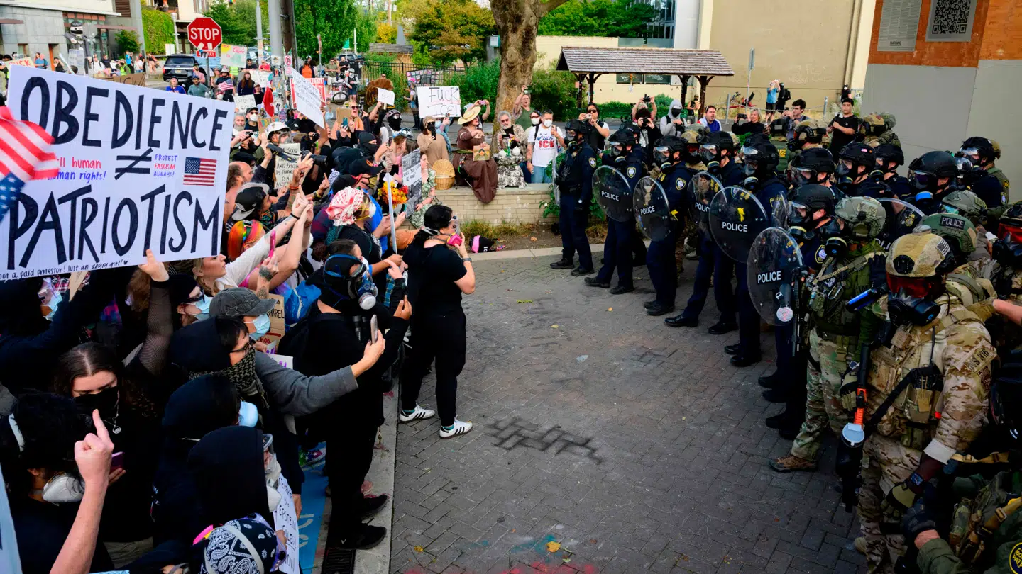 Demonstranter på venstre side og politi på højre side i Portland, Oregon. Flere demonstrationer har udviklet sig voldsomt de seneste uger.