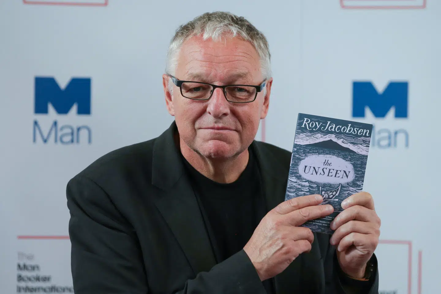 Den norske forfatter Roy Jacobsen poserer med sin bog "The Unseen" ved en konference i London i 2017. (Arkivfoto).