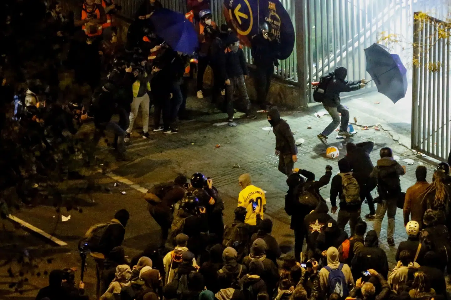 Flere demonstranter forsøgte at trænge ind på Camp Nou med paraplyer som værn. Pau Barrena/Ritzau Scanpix