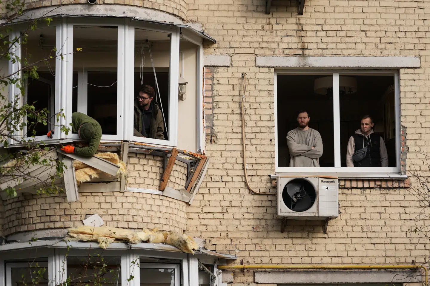 Billede fra tidligere på ugen, hvor indbyggerei Kyiv forsøger at reparere skade på lejlighedsbygning efter angreb. (Arkivfoto).