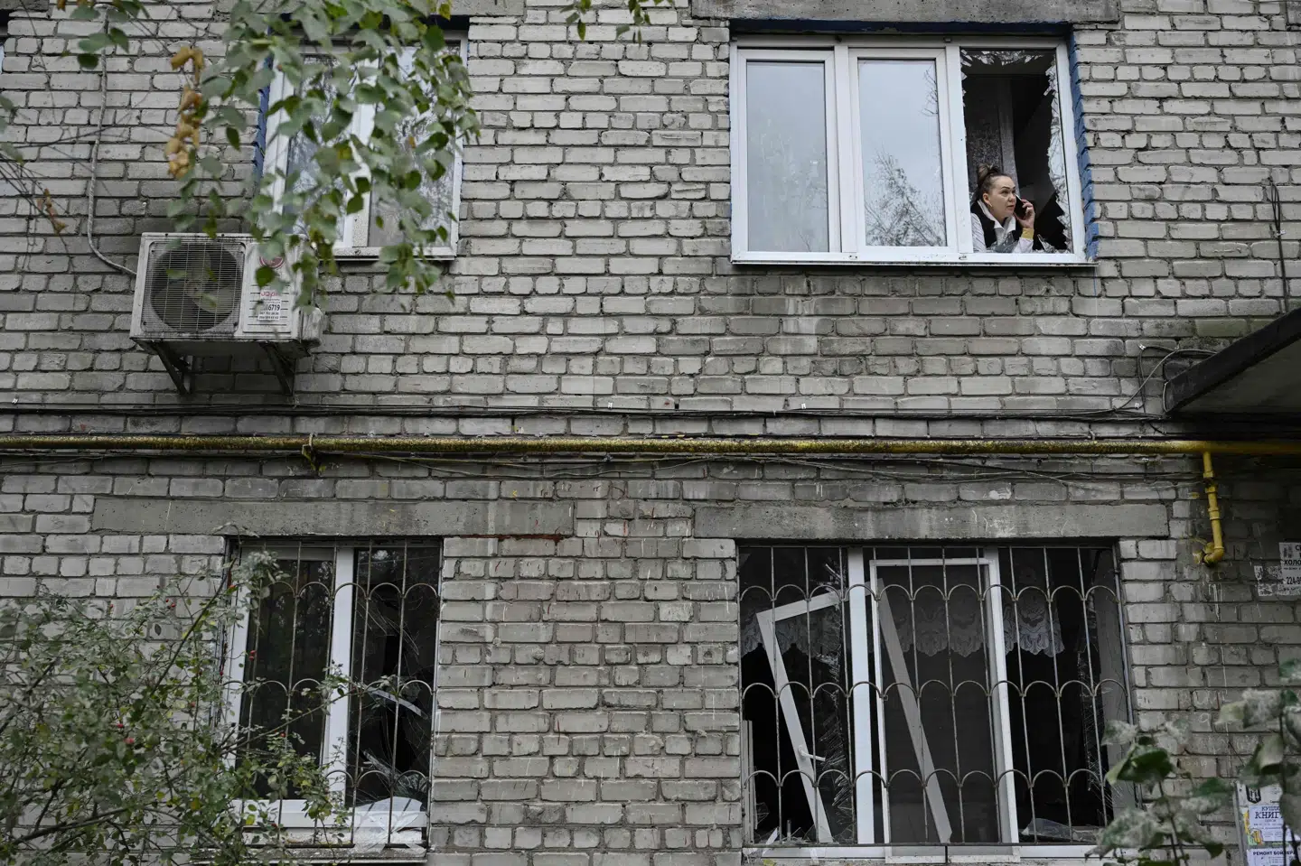 Billedet er fra lørdag, hvor Kyiv også var under angreb, og viser en indbygger, som taler i telefon i en beskadiget bygning i den ukrainske hovedstad.