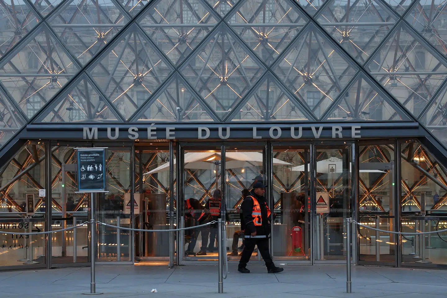 En sikkerhedsvagt kan ses patruljere foran kunstmuseet Louvre i Paris, efter at fransk politi søndag anholdt flere personer mistænkt for et røveri på museet 19. oktober. (Arkivfoto).