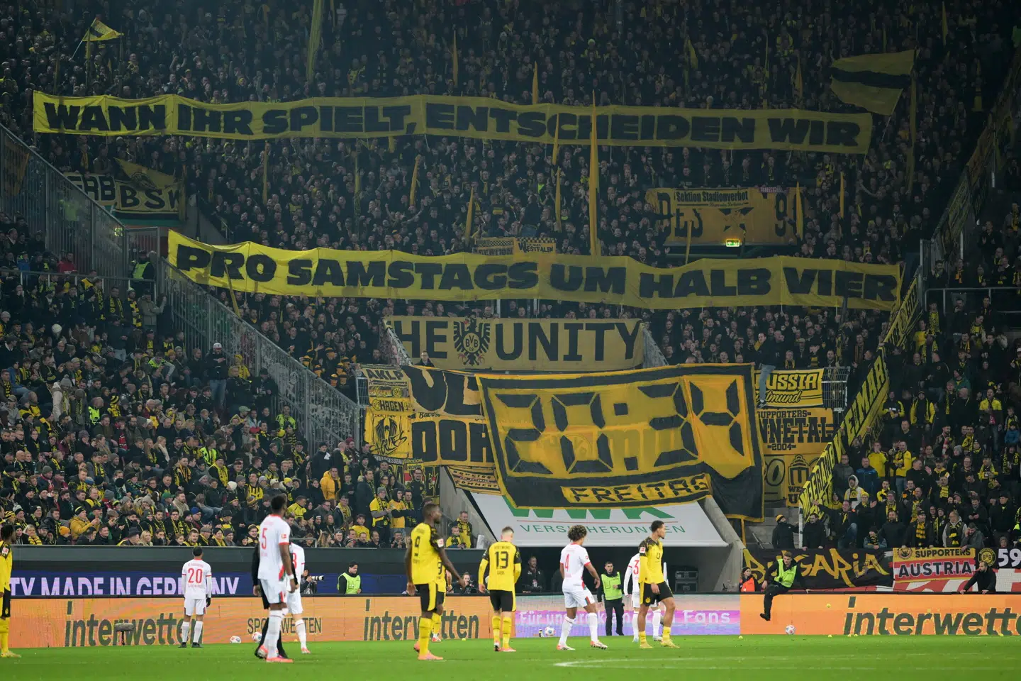 Dortmunds fans protesterede mod kamptidspunktet med bannere og kastede et væld af tennisbolde på banen.