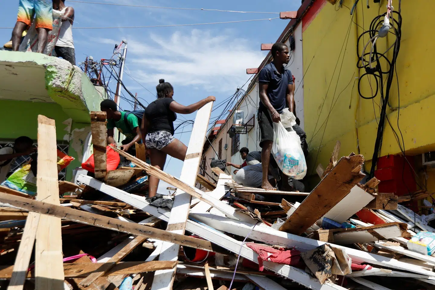 Indbyggere i Black River gennemsøger ruinerne af det, der inden orkanen Melissa var en butik. Det gør de for at finde mad og vand.