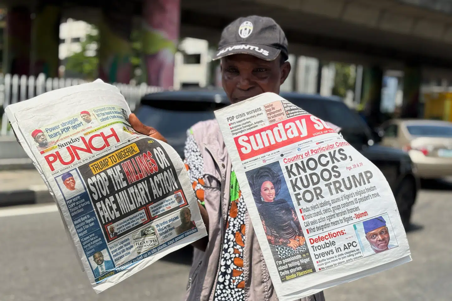 En avissælger i storbyen Lagos i Nigeria viser søndagens avisforsider, som handler om Trumps trussel om en militær invasion.