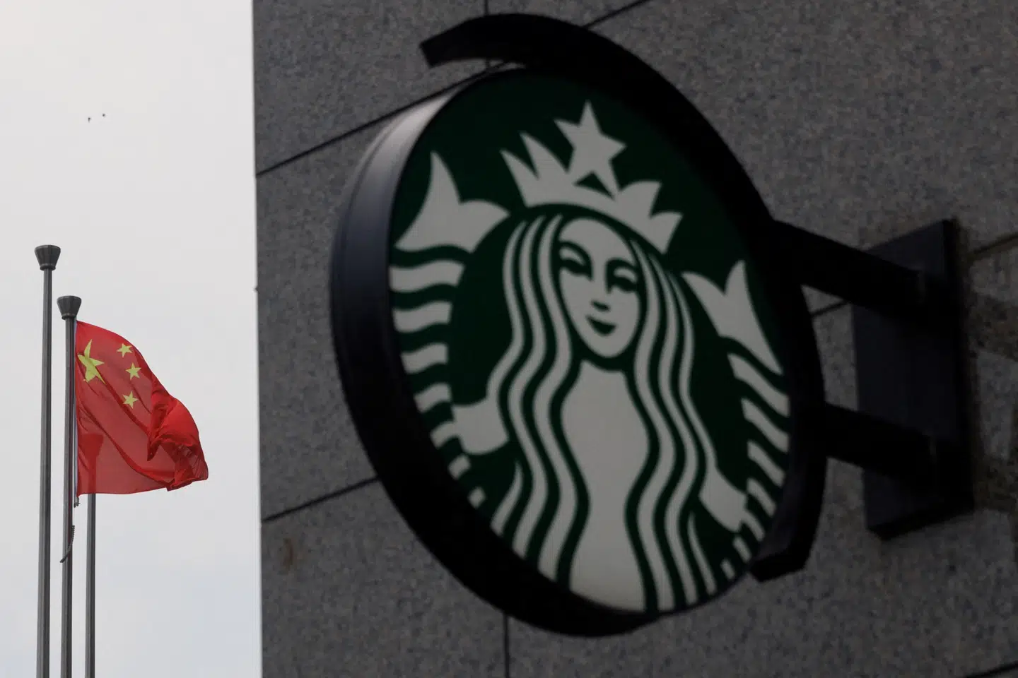Det kinesiske flag vajer uden for en Starbucks-café i den kinesiske hovedstad, Beijing. Nu køber en hongkonginvestor 60 procent af Starbucks' kinesiske forretning.