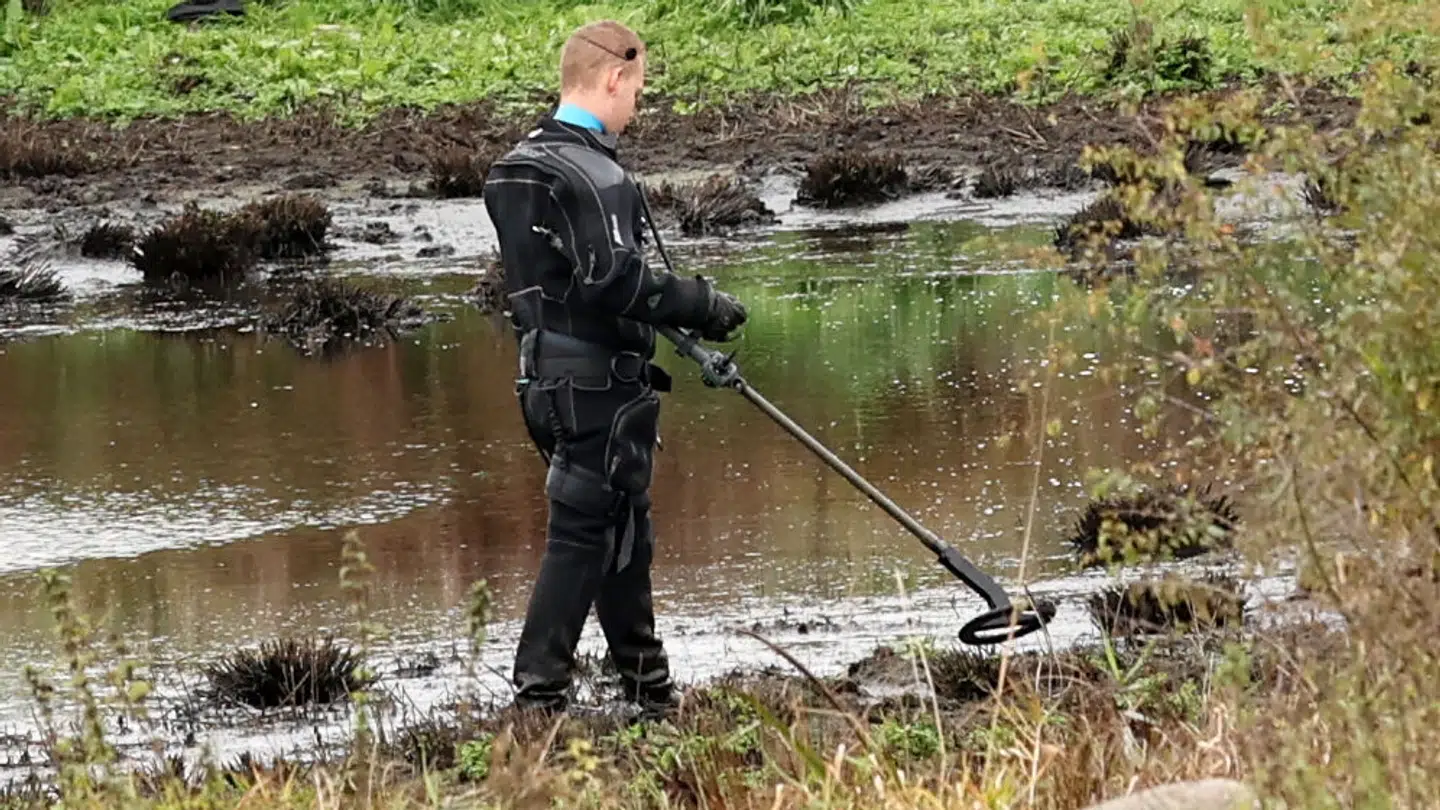 En politimand med minesøger afsøger det område nær et lille vandhul, hvor liget af den otte-årige skoledreng blev fundet i midten af oktober.