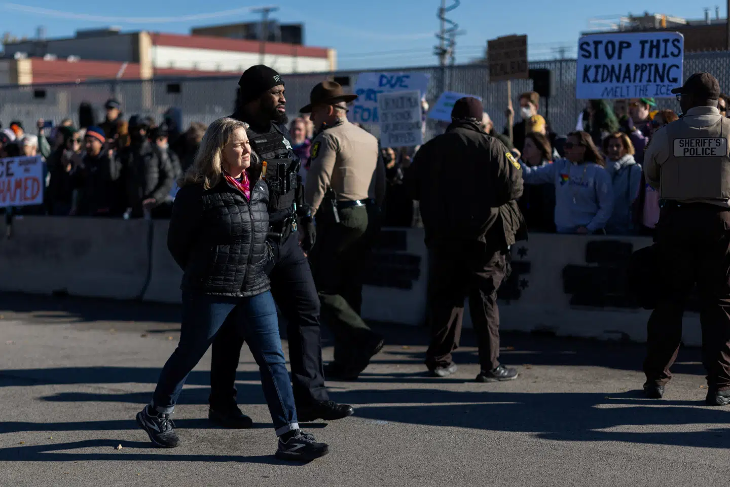 Her ses en betjent føre en kvinde væk under en demonstration mod immigrationsaktionerne i Chicago den 7. november.