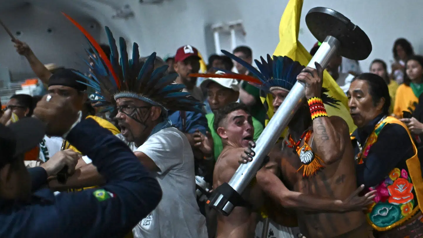 Demonstranter ses her støde sammen med sikkerhedsstyrker, da de invaderede et afspærret område ved COP30-hovedkvarteret i Belém, Brasilien, den 11. november.