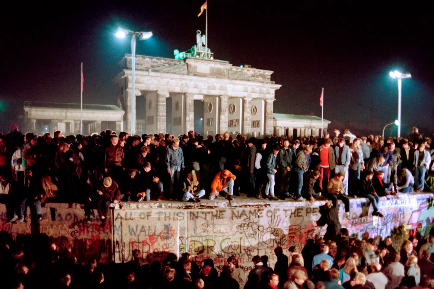 Unge østberlinere fester på toppen af Berlinmuren ved Brandenburger Tor 11. november 1989 – to dage efter Murens Fald.
