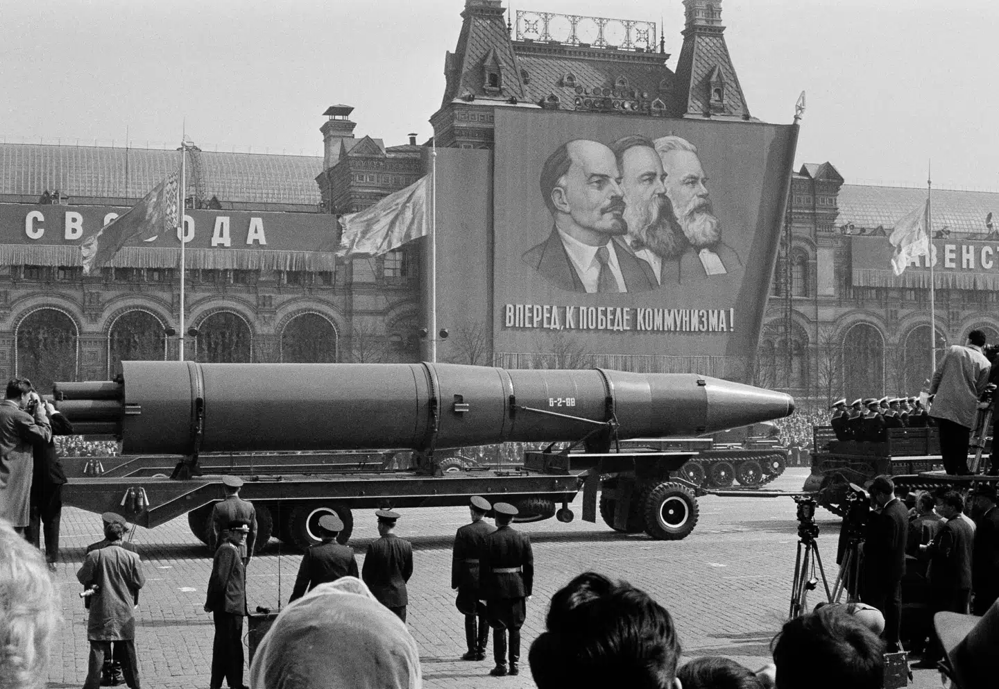 Her ses en 1. maj-parade på Den Røde Plads i Moskva tilbage i 1963. Bag raketten gemmer sig et banner med Vladimir Lenin (tv.), Friedrich Engels (mf.) og Karl Marx (th.)