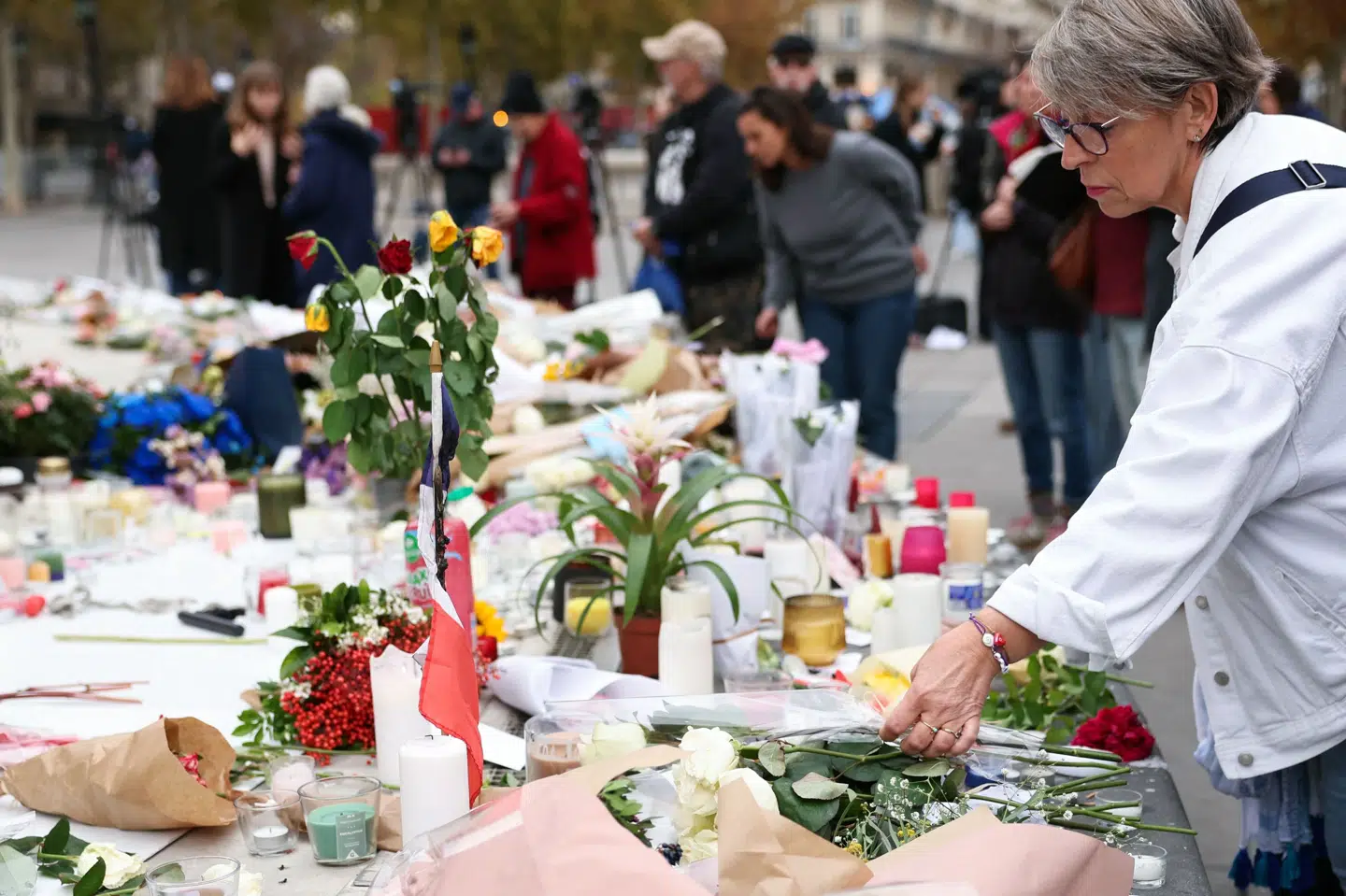 En kvinde lægger en buket blomster på Place de la République i Paris til minde om ofrene for angrebene 13. november 2015.