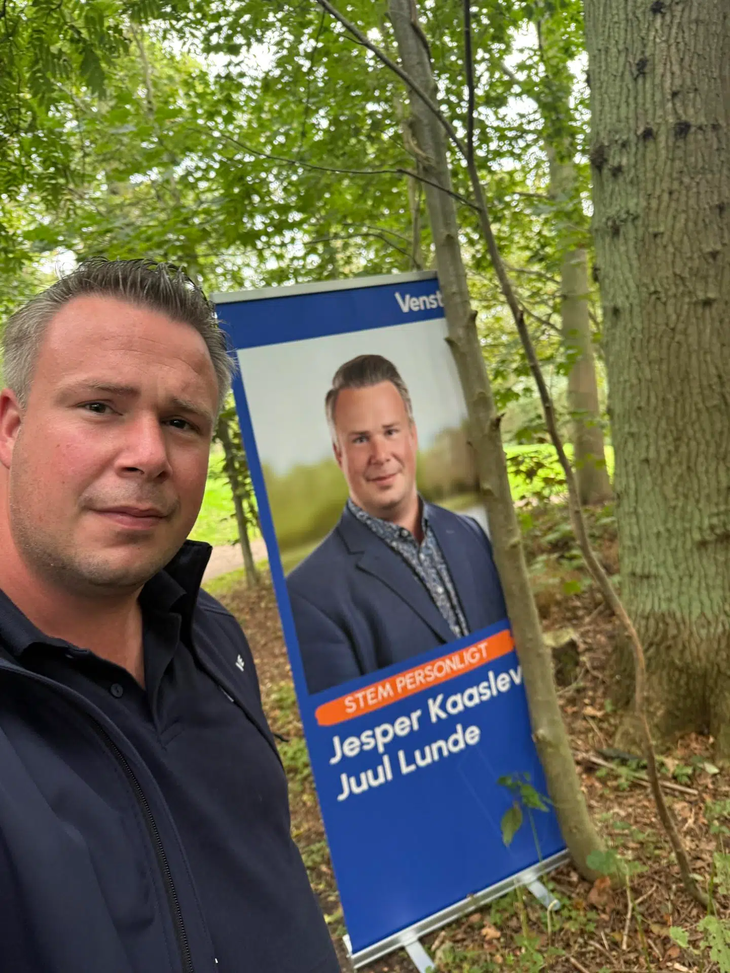 Her ses Jesper Kaaslev Juul Lunde foran et valgkampsbanner.