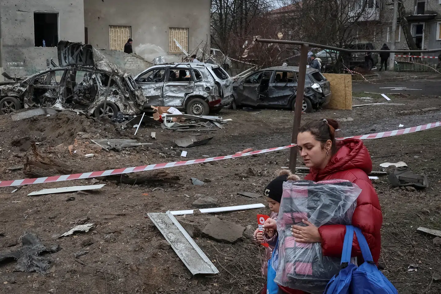 Billede fra Balaklija i ukrainske Kharkiv mandag. En indbygger kan ses med humanitær hjælp i armene efter angreb ved beboelsesejendom.