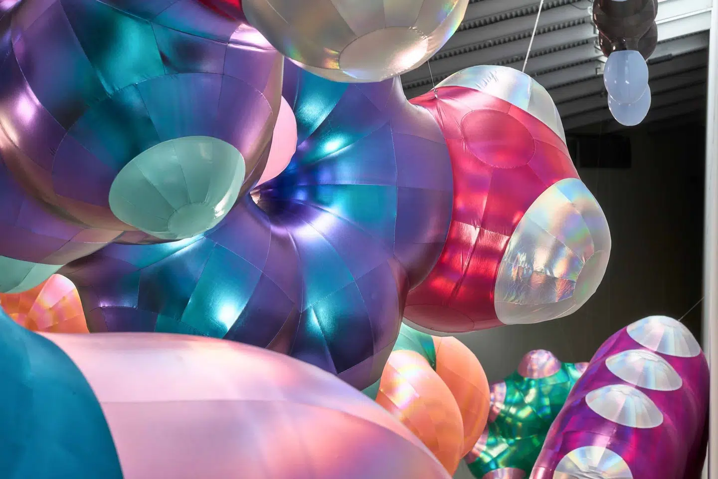 De glinsende badedragtstoffer, benzenmolekylerne er lavet af, har en changerende regnbueagtig kulør, på samme måde som olie i en vandpyt. Monira Al Qadiri, BENZENE FLOAT