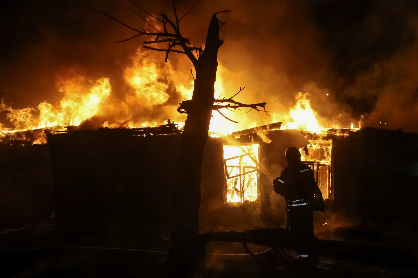 En brandmand forsøger at få bugt med flammerne i Ukraines næststørste by, Kharkiv, efter et angreb søndag. Flere personer meldes dræbt.
