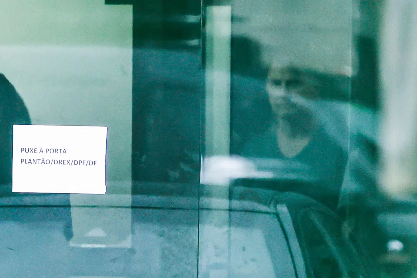 Brasiliens tidligere præsident Jair Bolsonaro ses gennem en glasdør i det føderale politis hovedkvarter i Brasilia i Brasilien. Han er blevet flyttet fra husarrest til et fængsel, efter at han angiveligt forsøgte at fjerne sin fodlænke.