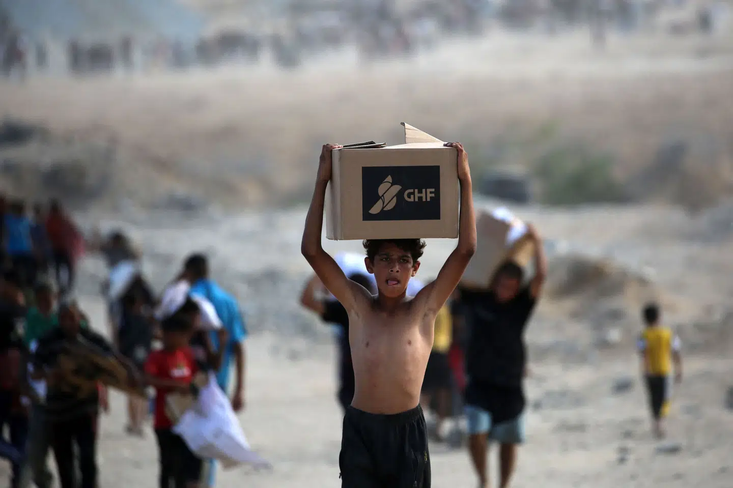 En palæstinensisk dreng bærer en kasse fra Gaza Humanitarian Foundation (GHF) kort inden indgåelsen af våbenhvileaftalen i Gaza i begyndelsen af oktober. Mandag meddeler GHF, at organisationen har afsluttet sit arbejde i området. (Arkivfoto).