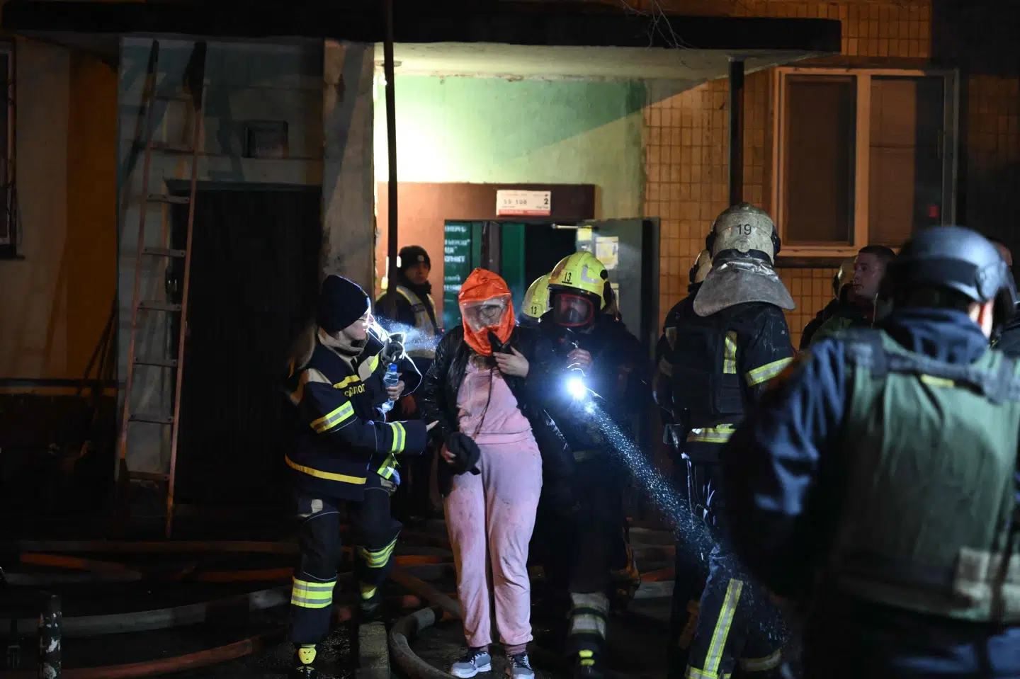 Lejligheder i Kyiv blev i nat evakueret efter et russisk droneangreb. Her hjælper brandfolk en kvinde ud af en beskadiget ejendom.