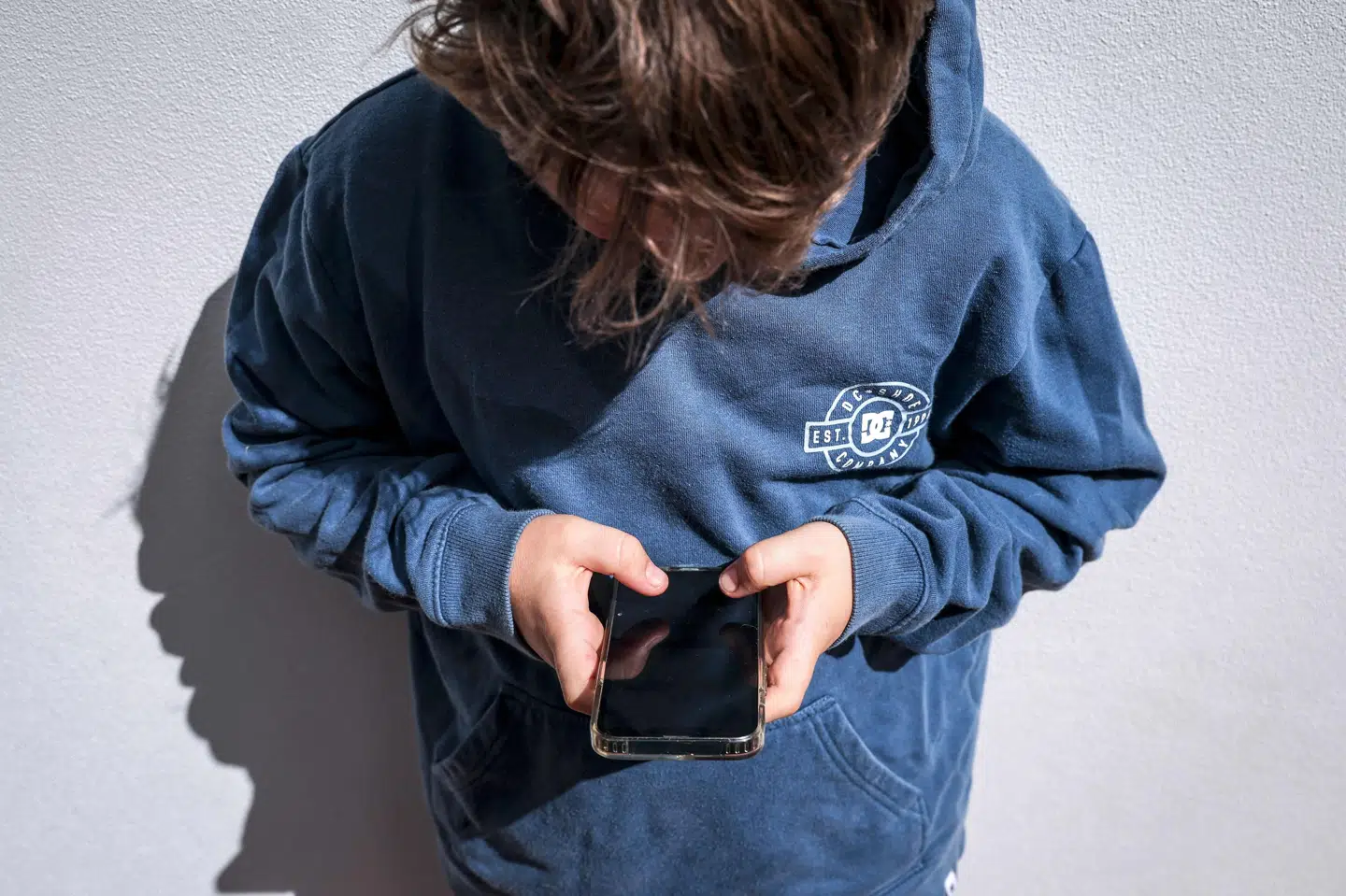 En 14-årig dreng bruger sin telefon i sit hjem i Gosford på den australske østkyst. Fra 10. december er det ikke længere lovligt for børn under 16 år at have en profil på sociale medier som Facebook og TikTok. (Arkivfoto).