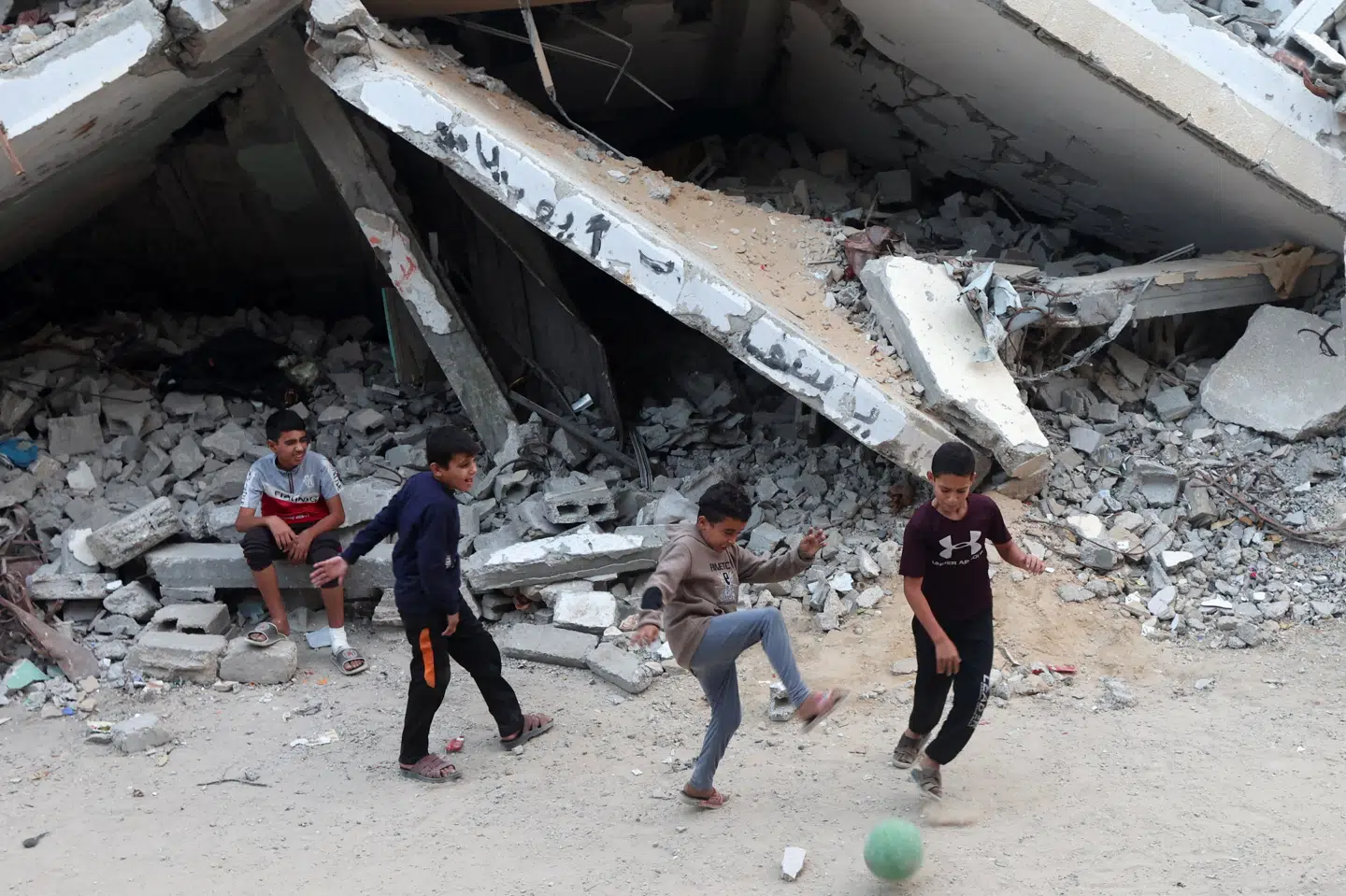 Børn spiller fodbold mellem murbrokker og ødelagte bygninger i Khan Younis i det sydlige Gaza tidligere på ugen. Lørdag er to børn ifølge Reuters og Haaretz blevet skudt af israelske styrker i området.