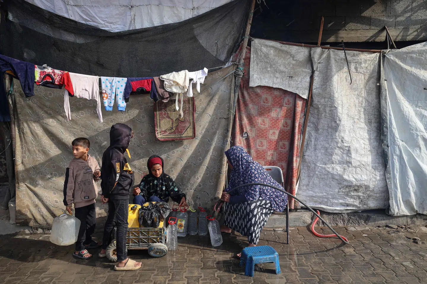 En kvinde fylder beholdere med vand i en flygtningelejr i Gaza. Netop Gaza er kommet på aftalepartiernes bud på Norges finanslov for næste år. Norges regering og to aftalepartier vil sende en hjælpepakke på en milliard norske kroner til området.