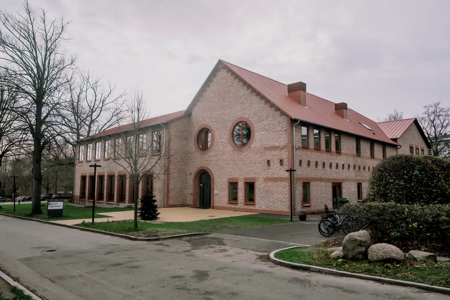 Teglborterne, de fine stik over vinduerne, buerne og til en vis grad stærekasserne er alle hilsner til den store murstensarkitekt Martin Nyrop, som tegnede det oprindelige Bispebjerg Hospital
