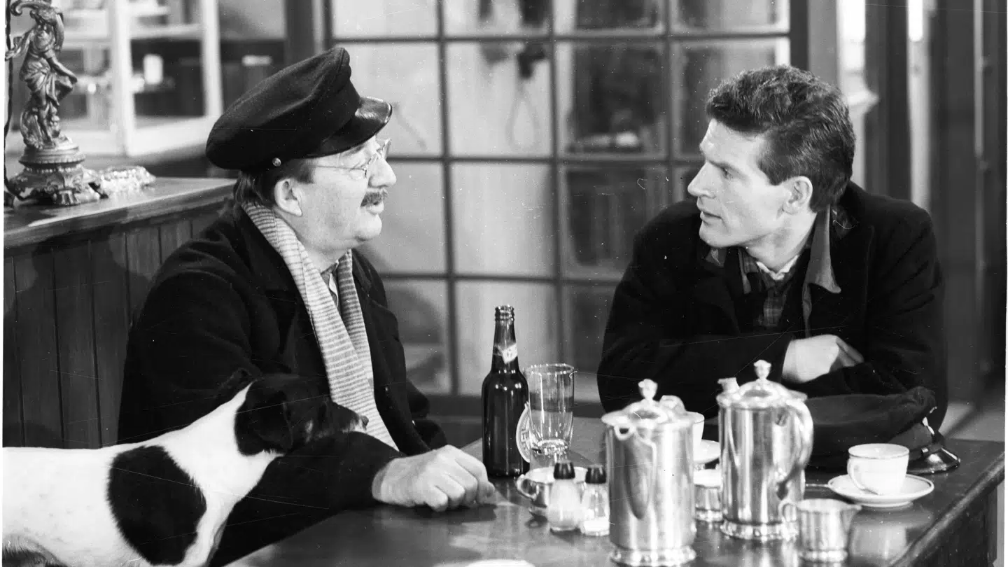 En klassisk scene på 'Matador,' hvor grisehandleren Oluf Larsen drikker en øl med Røde på Jernebanerestauranten.