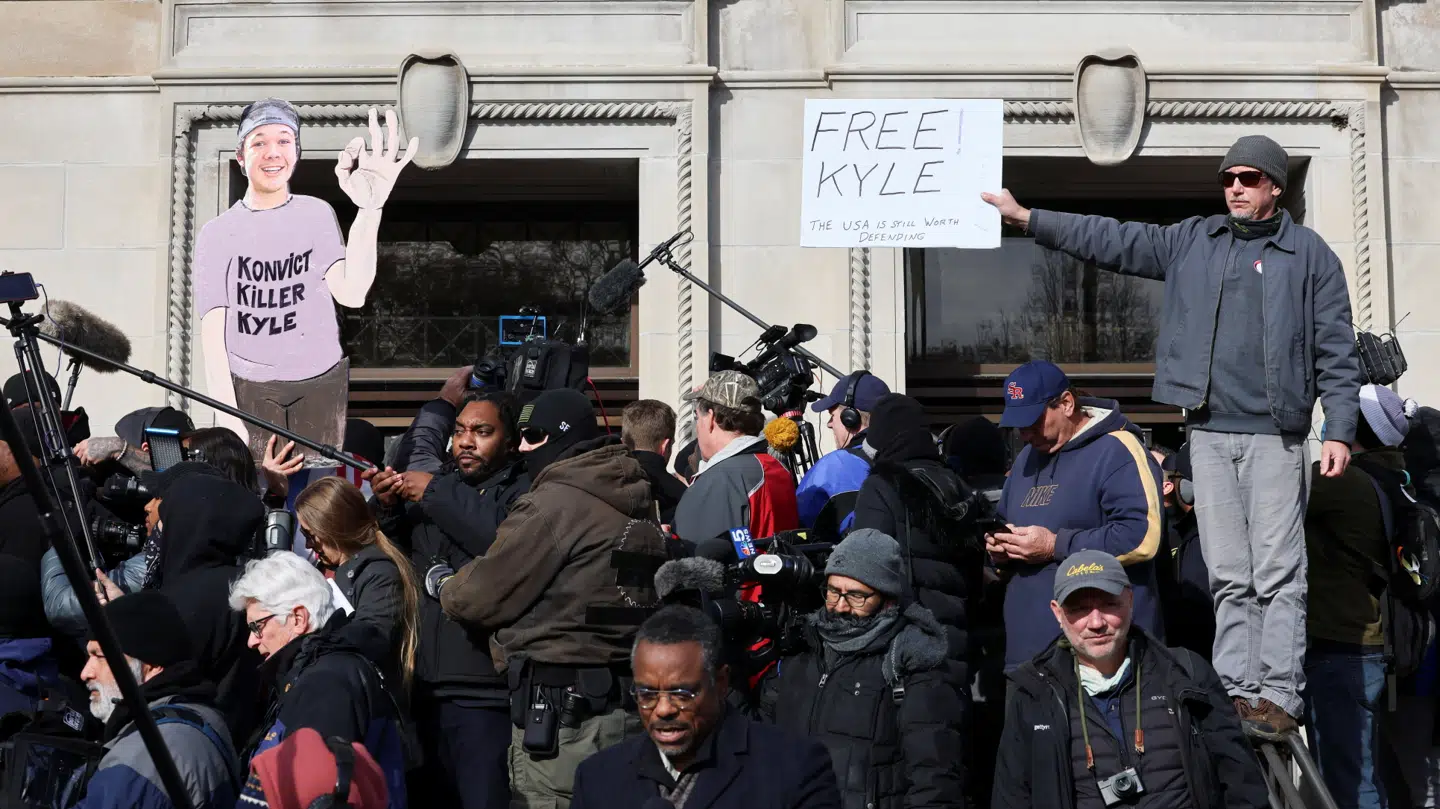 Et godt billede på, hvordan Kyle Rittenhouse blev en historie, der delte USA. Enten mente folk, han var en morder eller også mente de, han var en helt. 'Døm morder Kyle', står der på skiltet til venstre. 'Befri Kyle' står der på skiltet til højre.