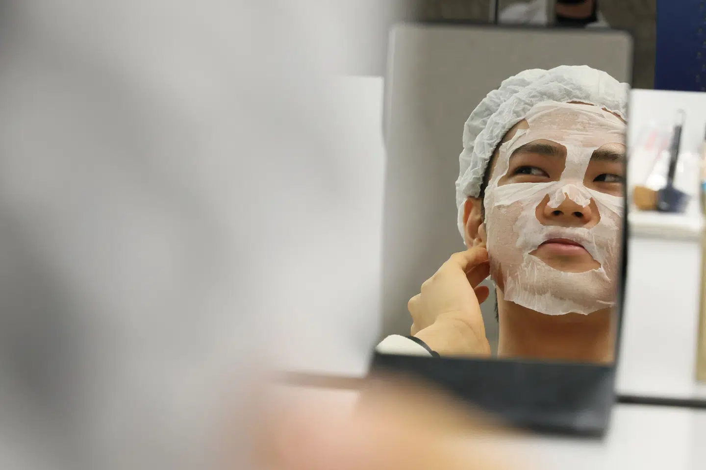 Forbrugerrådet Tænk mener, at knap en tredjedel af i alt 55 ansigtsmasker har problematiske kemikalier i sig. På billedet tager en mand en ansigtsmaske på 4. december i Japan. (Arkivfoto).