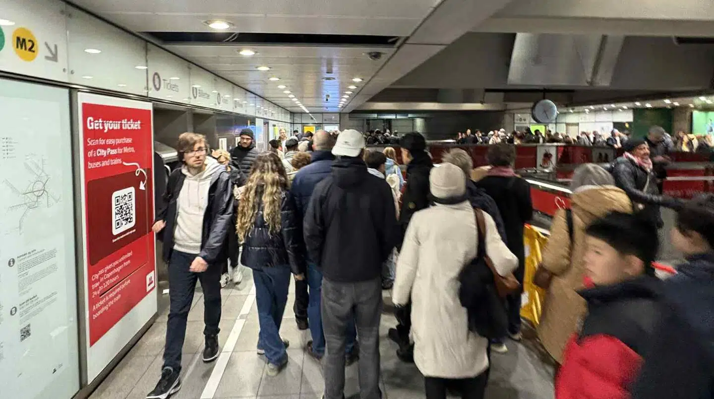 Mange hundrede rejsende venter tålmodigt på at komme med en metroafgang på Kongens Nytorv.