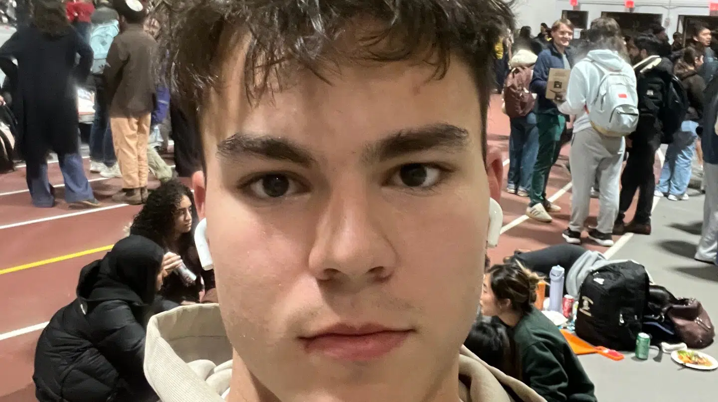 Her sidder Mads Mathiesen evakueret i atletikhal på Brown University efter skoleskyderiet natten til søndag dansk tid.