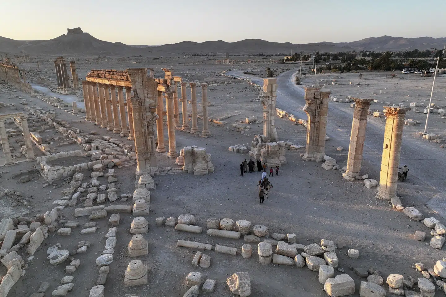 Lokale besøgende går mellem søjlerne i oldtidsbyen Palmyra i Syrien, hvor amerikanske soldater lørdag blev angrebet. Billedet er fra august. (Arkivfoto).