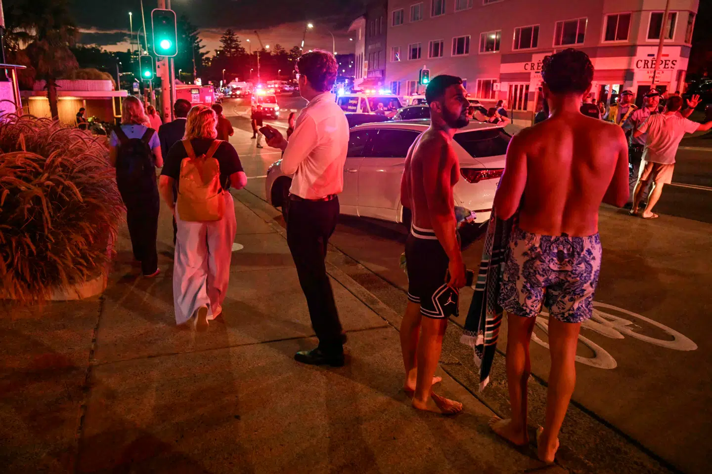 Folk stod i gaderne ved Bondi Beach efter angrebet i Sydney søndag aften lokal tid.