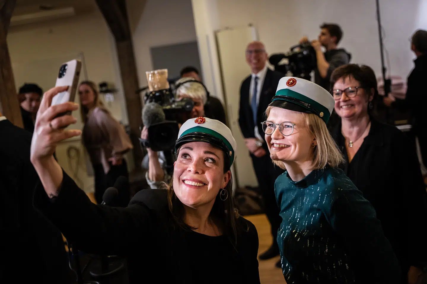Astrid Kragh (S) og Sofie Lippert (SF) efter præsentationen af aftalen om en ny gymnasieuddannelse i februar. De to politikere har taget en grøn studenterhue på, som skal høre til epx. (Arkivfoto).