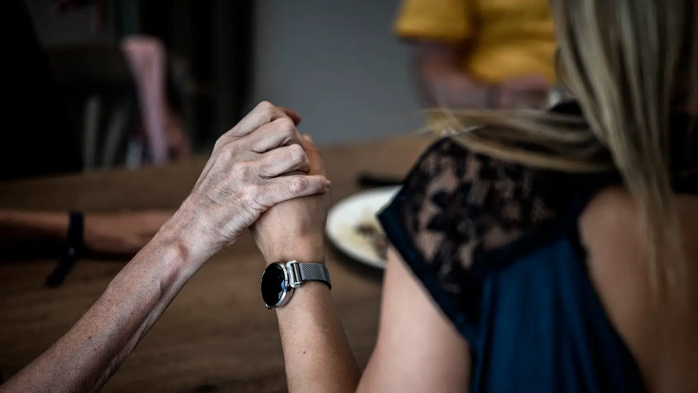 Arkivfoto af en frivillig, som holder en Alzheimers-patient i hånden i Frankrig.