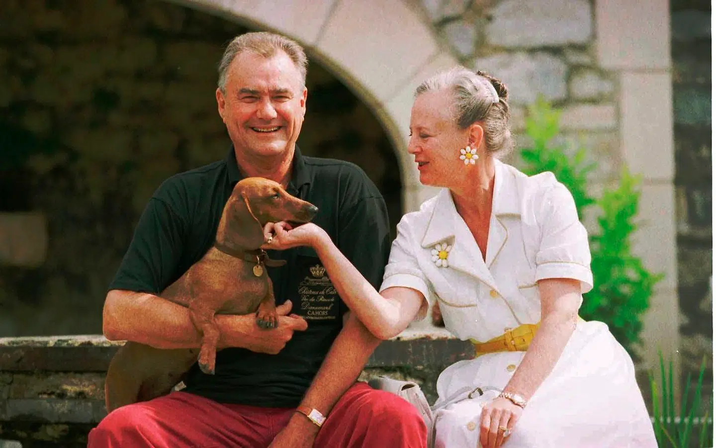 Her ses dronningen sammen med prinsgemalen og gravhunden Celime. Dronning Margrethe er i den hvide kjole fra Ferragamo, som hun har båret så ofte. Man kan tit se hende have marguerit-øreringene og -brochen på til netop den hvide bomuldskjole.