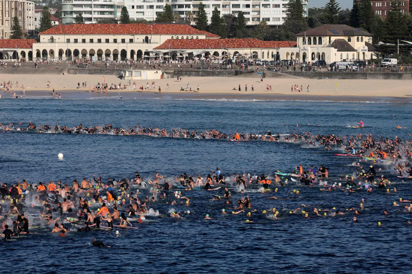 Svømmere og surfere samles fredag morgen i bølgerne ved Bondi Beach for at mindes ofrene for et masseskyderi på stranden søndag.