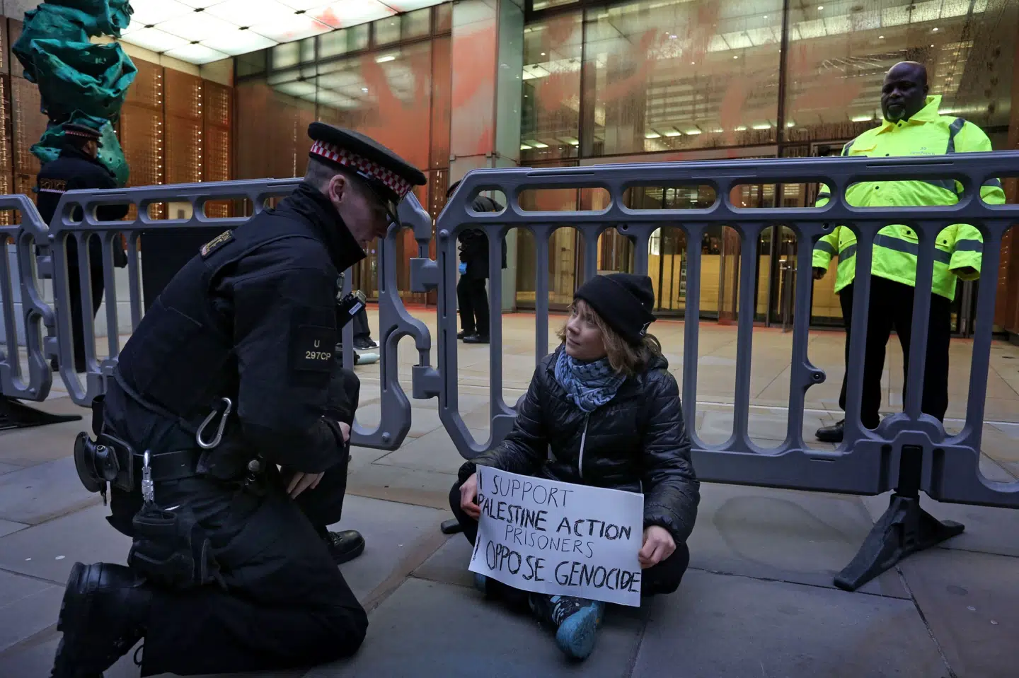 Greta Thunberg taler med en betjent under en demonstration foran forsikringsfirmaet Aspen i London.