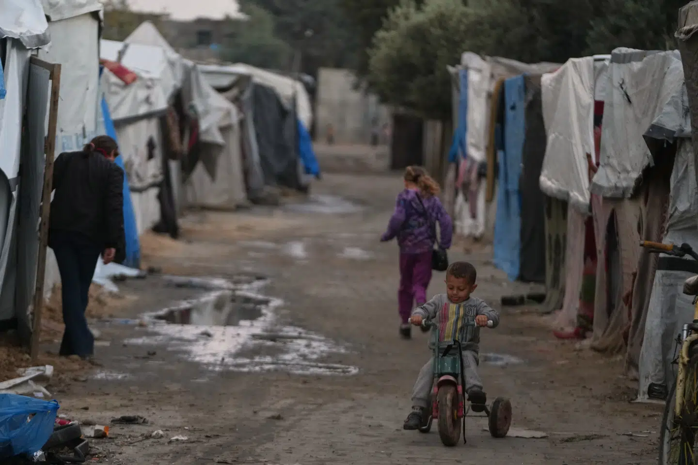 En palæstinensisk dreng kører på en trehjulet cykel i en af de midlertidige lejre for fordrevne palæstinensere i Gazastriben. Vejen til anden fase af den våbenhvileaftale, der blev indgået i oktober, er fuld af forhindringer.