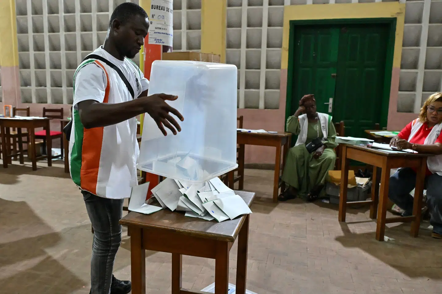 En medarbejder fra Elfenbenskystens uafhængige valgkommission, CEI, hælder lørdag stemmesedler ud på et bord under optællingen af stemmer til parlamentsvalget.