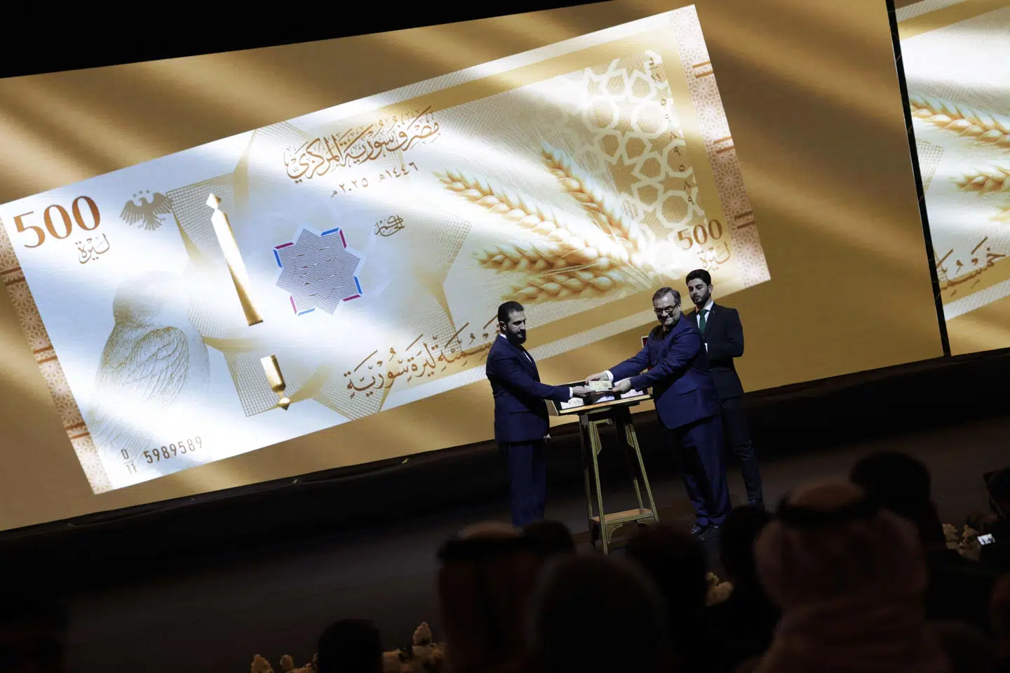 Syriens præsident, Ahmed al-Sharaa, og landets centralbankchef, Abdul Qadir al-Hasriya, ses mandag med ny pengeseddel i Damaskus.