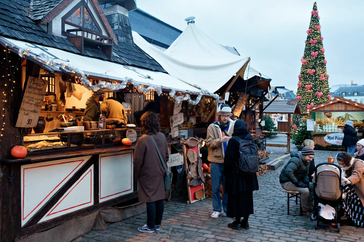 Julemarkederne er populære besøgsmål, og kreditkortet bliver svinget mere og mere. Her er det en madbod med kød og friskrøget laks på Thorvaldsens Plads i København.