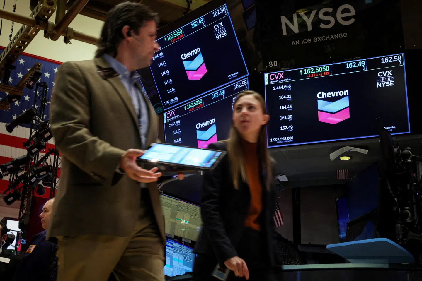 FILE PHOTO: Traders work on the floor as screens display the logo for Chevron Corp. at the New York Stock Exchange (NYSE) in New York City, U.S., October 23, 2023. REUTERS/Brendan McDermid/File Photo