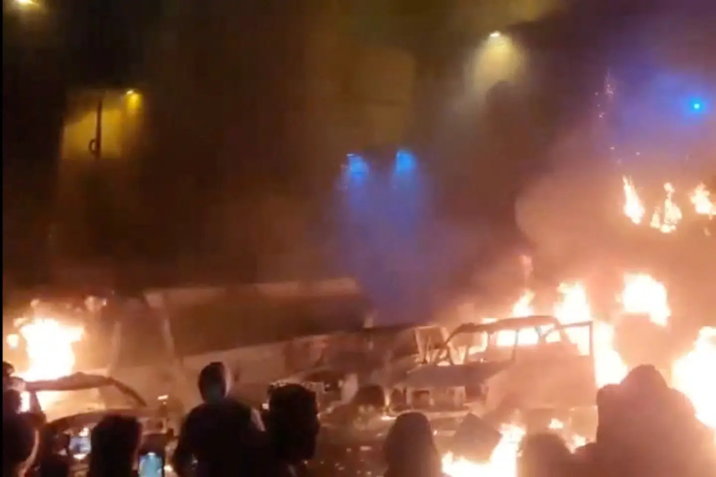 Biler er brudt i brand under demonstrationer i Irans hovedstad, Teheran. Billedet stammer fra en videooptagelse, som er blevet offentliggjort på sociale medier fredag.