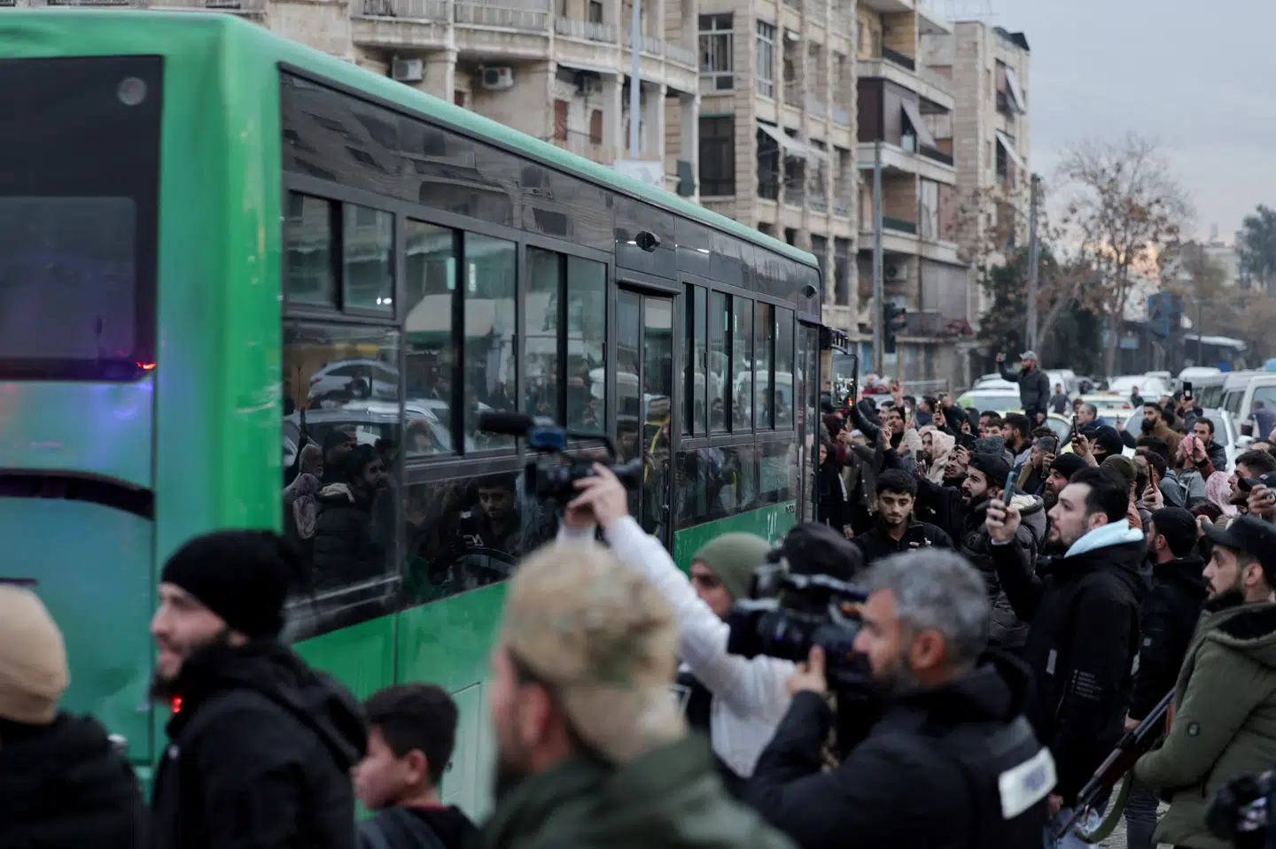 Folk har samlet sig i Sheikh Maqsoud i Aleppo ved en bus, hvis passagerer ifølge syriske embedsmænd er kurdiske militante, som har overgivet sig.
