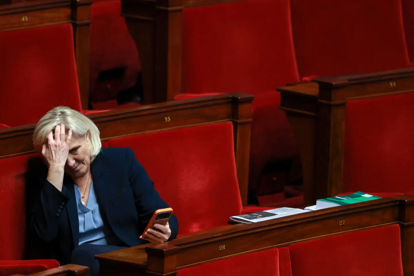 Marine Le Pen tager sig til hovedet under en debat i den franske nationalforsamling. Lederen af det højrenationale parti Rassemblement National risikerer sit politiske liv, hvis appelretten i Paris stadfæster en dom om svindel med EU-midler.