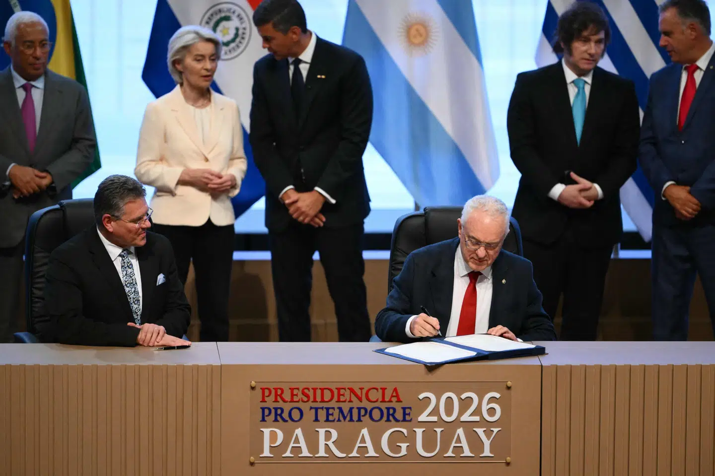 Uruguays udenrigsminister, Mario Lubetkin, underskriver handelsaftalen mellem Mercosur og EU. Ved siden af ham sidder EU's kommissær for handel og økonomisk sikkerhed, Maros Sefcovic. Bag dem står blandt andre EU-Kommissionens formand, Ursula von der Leyen.