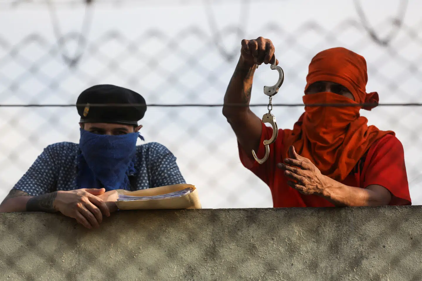 Indsatte står i et vagttårn i fængslet Renovacion 1 og fremviser håndjern, efter at de har taget fængselsbetjente som gidsler i Guatemala.