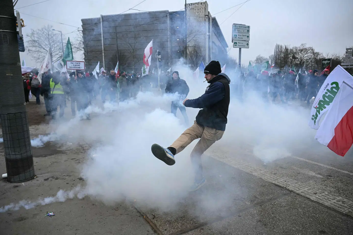 En demonstrant sparker til en tåregasgranat under sammenstød med politiet uden for EU-Parlamentets bygning i Strasbourg forud for afstemningen. Aftalen er blevet vedtaget af et kvalificeret flertal af EU-landene, men store landbrugslande som Frankrig og Polen stemte i mod (Arkivfoto).